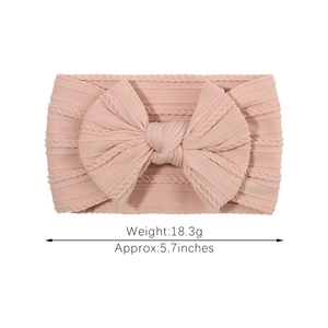 Pink soft nylon headband for babies featuring a large bow and ribbed knit texture