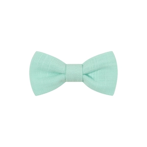 Detailed close-up showing the textured mint green fabric weave of the kids' bow hair clip