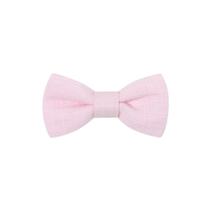 Close-up of pink linen fabric bow hair clip showing textured cotton weave details