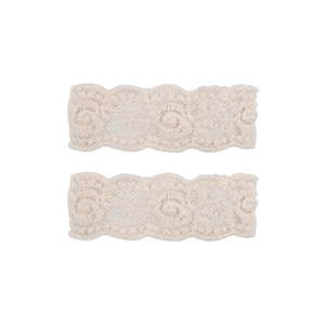 Detailed view of two cream lace fabric bows with vintage floral embroidery and scalloped edges