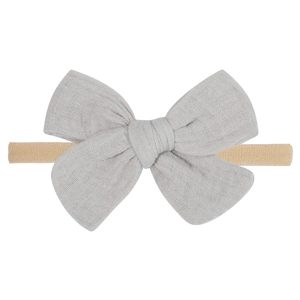 Detailed macro view of gray linen baby bow with ultra soft nude nylon headband texture