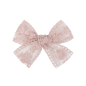 Detail of light pink lace bow with delicate floral embroidery and scalloped edges