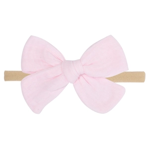 Soft pink cotton bow baby headband with highly elastic skin-tone nylon band on white background