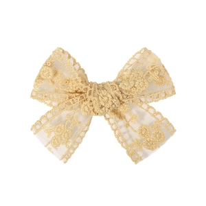 Detail of elegant beige lace hair clip with floral embroidery and bow design for girls