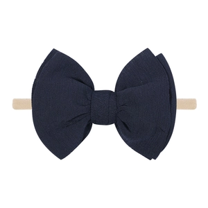Detailed view of dark blue bow hairband featuring soft high-elastic nylon and crepe fabric