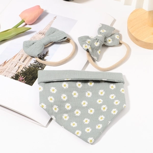 Baby gift set with two floral bow headbands and one matching green daisy bib
