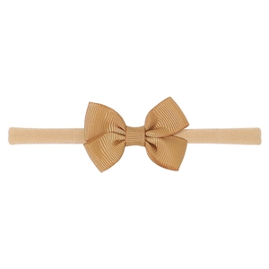 Detail of high-elastic baby headband featuring a classic golden grosgrain ribbon bow