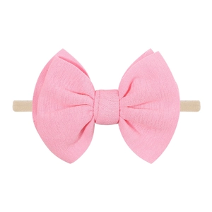 Détail du nœud rose en tissu texturé avec bandeau souple en nylon pour bébés