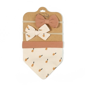Detail of floral baby bib and bow headband set on kraft paper card packaging