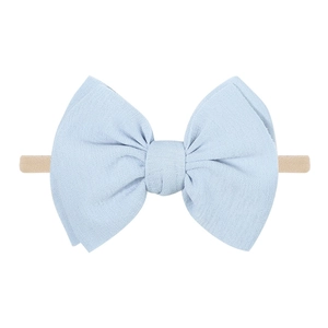 Détail d'un bandeau bébé avec un nœud bleu clair sur une bande en nylon douce extensible