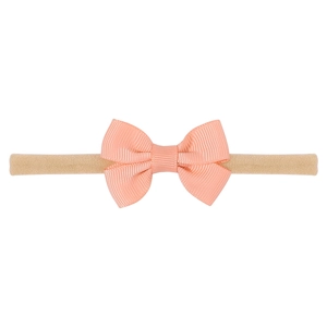 Detail view of handmade baby bow headband with high elastic nylon ribbon in apricot color