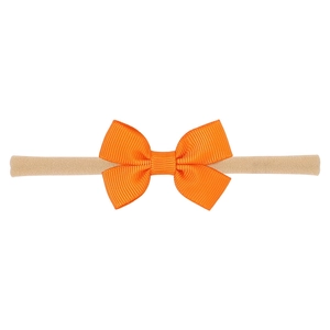 Close-up of vibrant orange grosgrain ribbon bow on a soft nude nylon baby headband