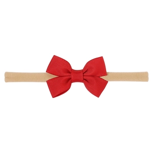 Detail of soft nylon infant headband with a large red ribbed grosgrain bow decoration