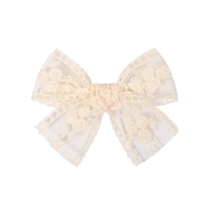 Detailed macro view of the intricate lace embroidery and floral texture on the hair clip
