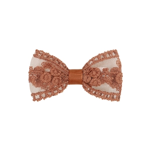 Détail d'un nœud en dentelle marron avec broderie florale et centre en ruban gros-grain