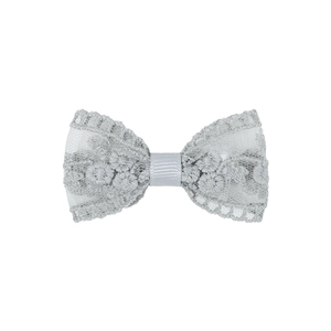 Détail d'un élégant nœud en dentelle brodée avec des motifs floraux et une texture fine