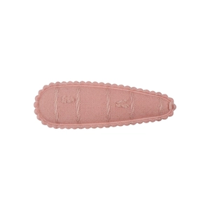 Vue détaillée d'une pince à cheveux en tricot rose avec bordure dentelle ondulée