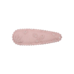Détail d'une pince à cheveux en tissu rose avec broderie florale et bords ondulés