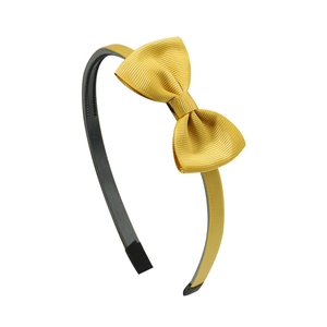 Detail of yellow ribbed grosgrain bow and black non-slip teeth on a children headband