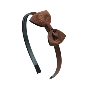 Close-up of dark brown handmade pleated bow headband with ribbed fabric texture details