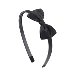 Detail showing the ribbed fabric texture and non-slip teeth of the black bow headband