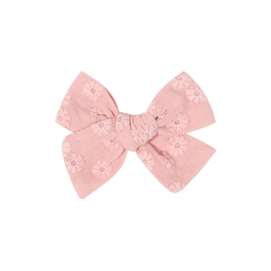 Detailed view of light pink cotton linen hair bow clip with delicate daisy embroidery