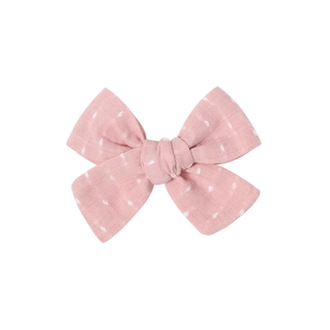 Detail of pink bow hair clip with white polka dots and high-quality cotton texture