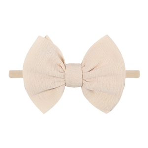 Close-up of beige elastic knit baby headband featuring a soft ribbed texture bow