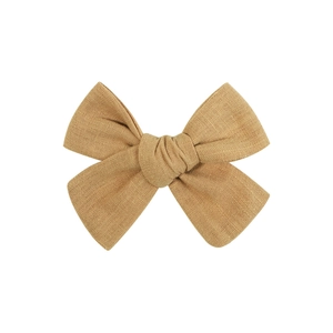 Détail d'un nœud papillon fait main en lin jaune gingembre avec texture sur fond blanc
