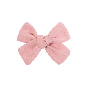 Vue détaillée d'une pince à cheveux à nœud rose montrant la texture du tissu en coton