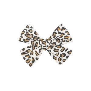 Detailed view of handmade fabric bow hair clip featuring classic leopard print pattern