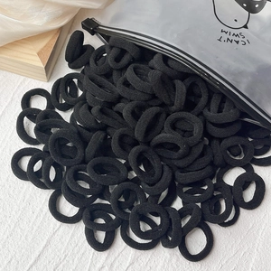 Set mit hochelastischen schwarzen Nylon-Haargummis und durchsichtigem Cartoon-Reißverschlussbeutel