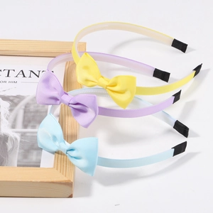 Three-piece set of girls bow headbands in pastel yellow, purple, and blue colors