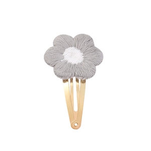 Détail de la pince à cheveux fleur au crochet avec un clip métallique doré brillant