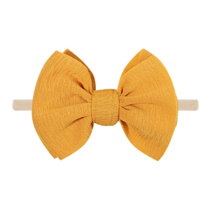 Close-up of yellow textured fabric bow and high-elastic nylon headband for infants