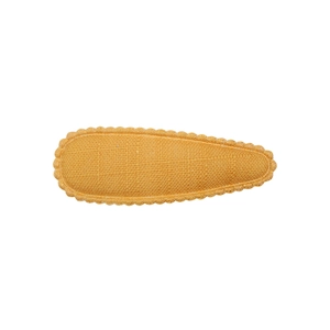 Detail view of mustard yellow fabric hair clip with wavy embroidered edges and texture