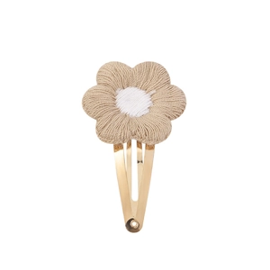 Detailed view of a handmade crochet flower hair clip with a gold metal BB clip base