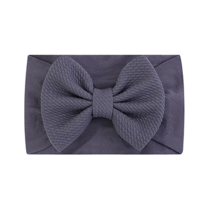Détail du bandeau bébé violet avec texture gaufrée élastique et grand nœud décoratif
