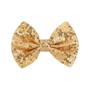 Detailed view of handmade golden sequin hair bow featuring glittery metallic finish