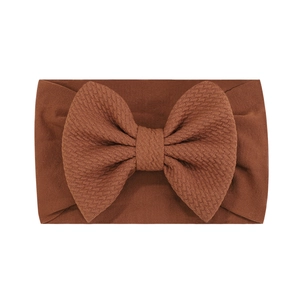 Détail d'un bandeau pour bébé en nylon jacquard marron avec un grand nœud très souple