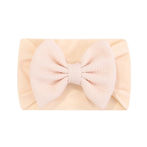 Vue détaillée du bandeau bébé avec texture gaufrée douce et décoration avec un grand nœud