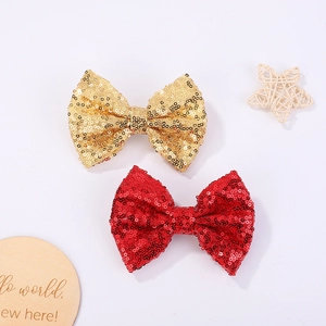 Close-up of sparkling gold and red sequin bow hair clips for girls' party hairstyles