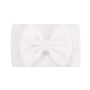 Détail d'un bandeau bébé en nylon jacquard blanc doux avec un nœud en maille gaufrée