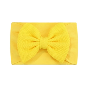 Détail du bandeau jaune pour bébé avec grand nœud en tissu gaufré et nylon ultra doux