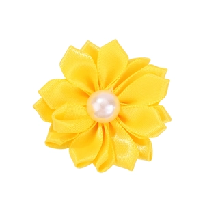 Détail macro du chouchou fleur en ruban de satin jaune avec perle nacrée centrale