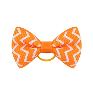 Close-up of orange grosgrain bow hair tie with white wavy pattern and elastic band