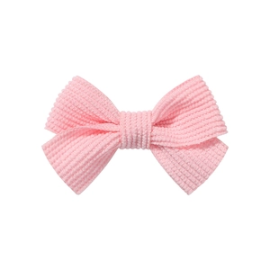 Detailed view of pink corduroy fabric bow hair clip with ribbed vertical texture