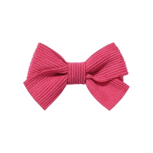 Detailed macro view of the rose pink striped corduroy texture on the bow hair clip