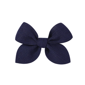 Macro shot of navy blue ribbed fabric hair bow clip with fine woven texture detail