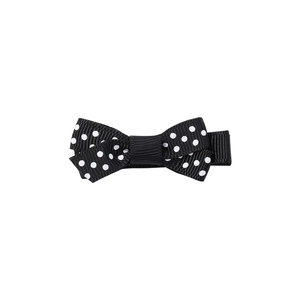 Dettaglio del fiocco per capelli in nastro grosgrain nero a pois bianchi per bambine